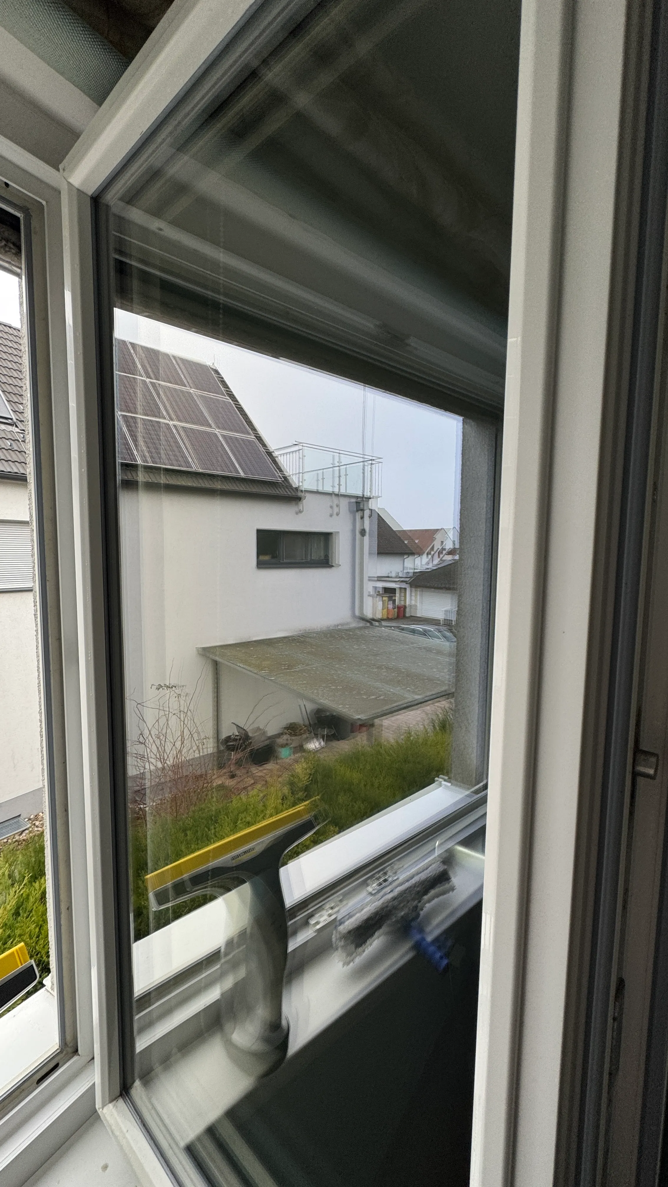 Streifenfrei gereinigtes Fenster mit Abzieher auf der Fensterbank bei der Fensterreinigung in Wien