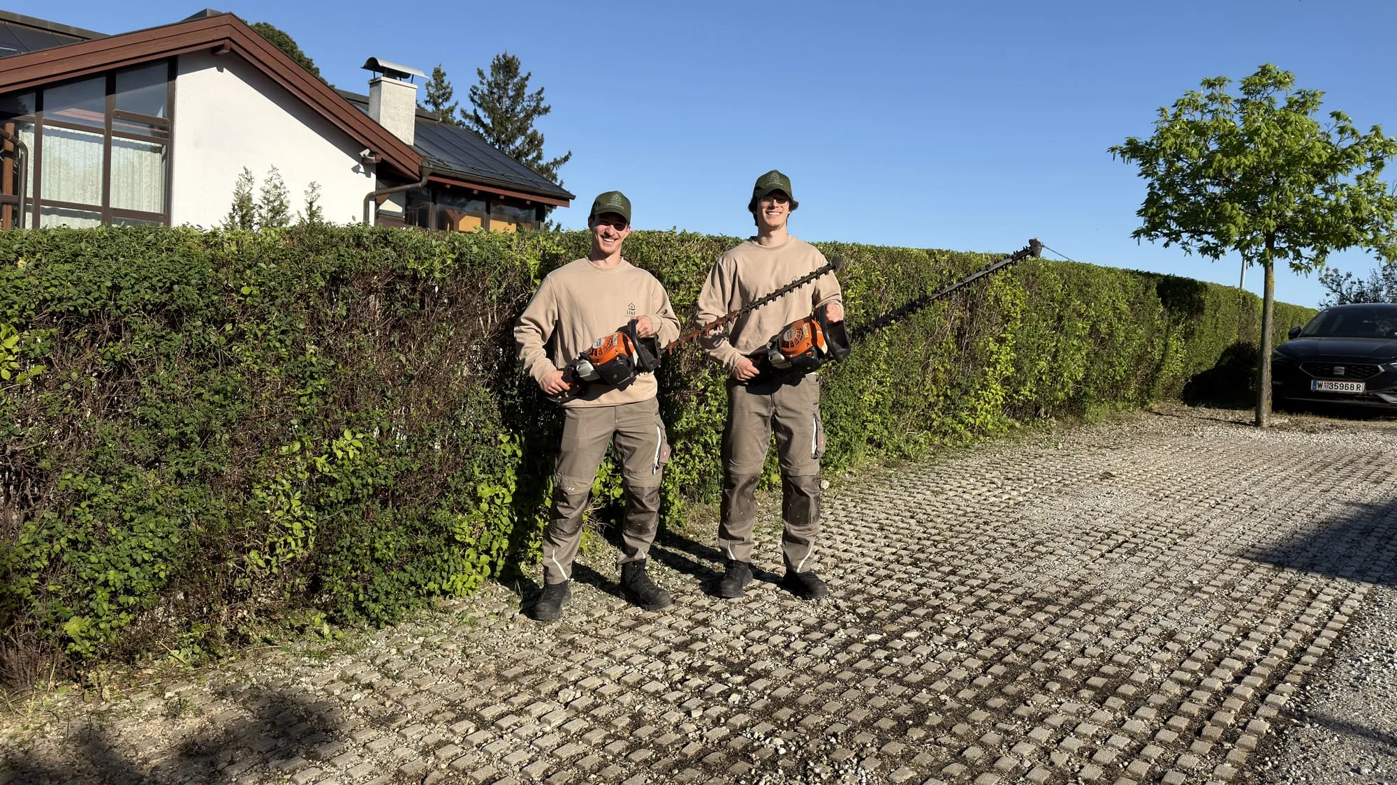 Team von H&F Gebäudeservice auf einer frisch gereinigten gepflasterten Einfahrt in Wien